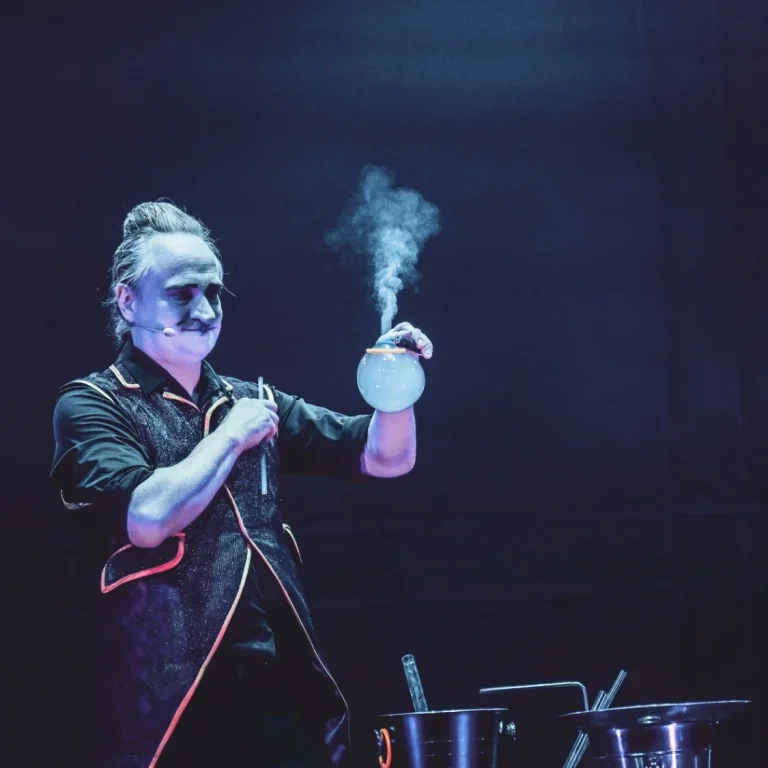 Magische bellenblaas show op bedrijfsevenement Iemand creëert een grote zeepbel op een podium voor een publiek.