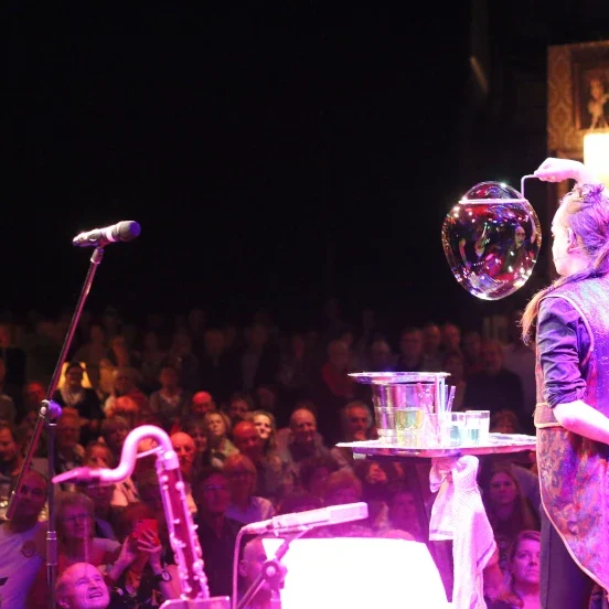 een bellenkunstenaar maakt een dubbele bellencarrousel met wijnglazen